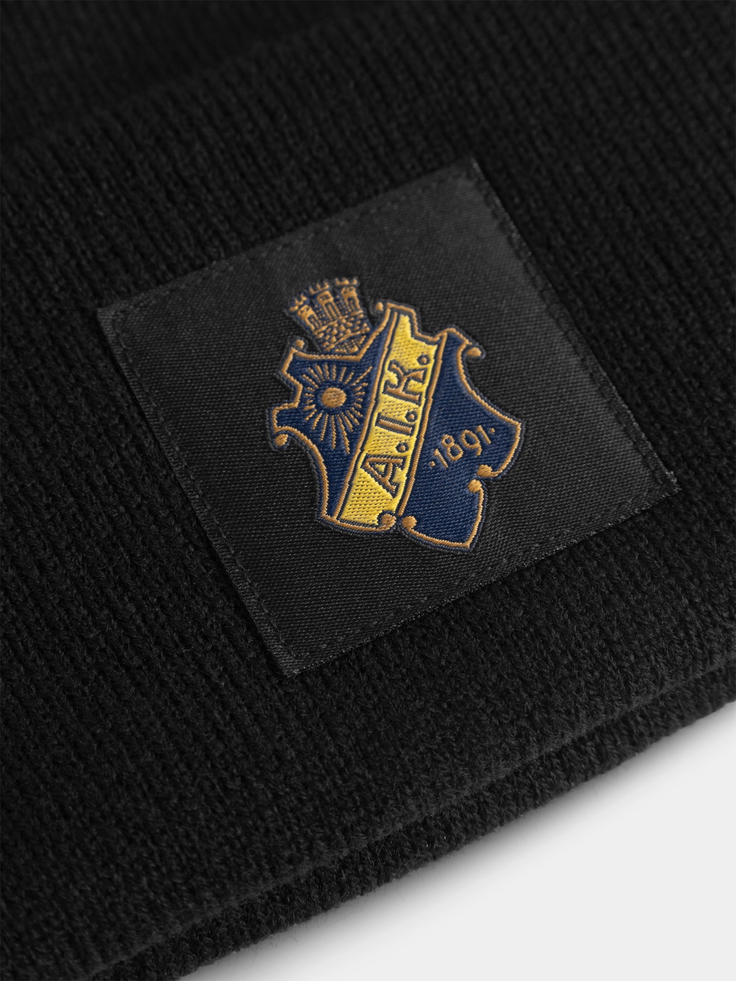 Stickad mössa Label sköld